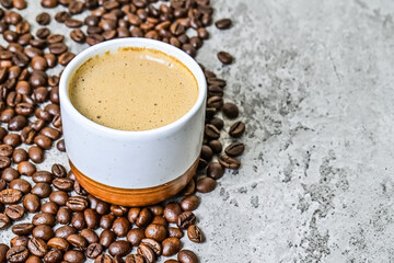 Close up view of hot cappucino in the ceramic mug or glass with coffee beans. scattered. copy space, empty, free, negative, design, text. grey or gray cement as background.