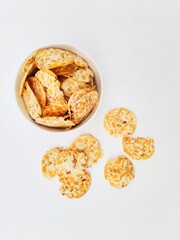 Tempeh chips in a white bowl on a white background. Top of view. 
