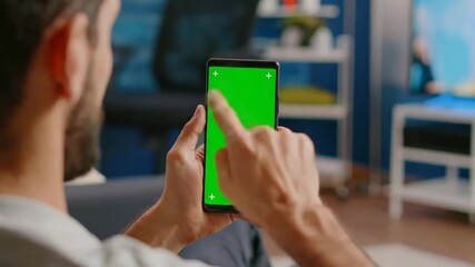 Man using smartphone with chroma key display for augmented reality experiences at home - Powered by Adobe