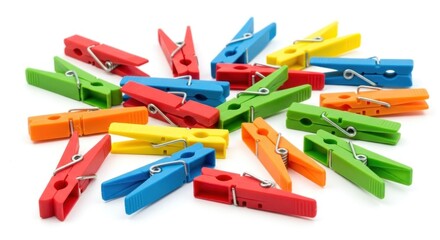 Scattered colorful plastic clothespins lay haphazardly on a white surface, creating a vibrant and playful arrangement
