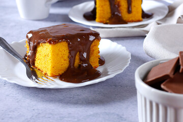 Slice of carrot cake with chocolate frosting on a ceramic plate. homemade Brazilian dessert