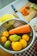Fresh raw cooking ingredients, chopped carrot, lime, and meat on wooden cutting board.