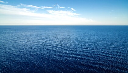 Vast expanse of deep blue ocean meeting a clear blue sky