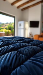 Close-up of a luxurious navy blue tufted sofa in a bright room with a view