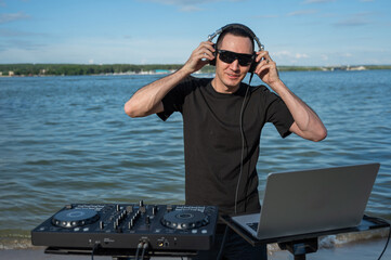 Male DJ playing music on the beach. 