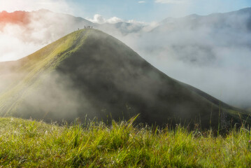 Aerial view from above of white puffy clouds Flying through the clouds above mountain tops.