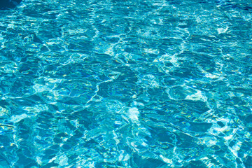 Blue pool water background. Blurred transparent clear calm water surface texture. Water waves in sunlight with copy space.