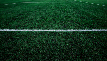 Close-up view of a green grass field with white lines, perfect for sports.