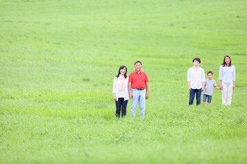 草原に立つ三世代家族