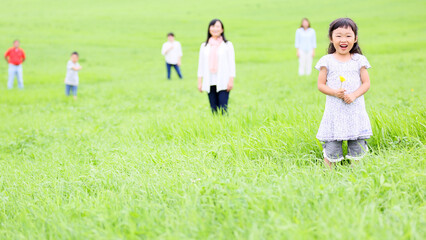 草原に立つ三世代家族