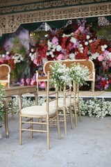 An Elegant Wedding Stage Adorned with Colorful Floral Decorations Cascading from Chairs, Blending Tradition and Romance
