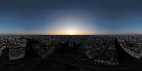 A panoramic aerial view of a city at sunset, where fading sunlight illuminates rooftops and streets, creating a dramatic and atmospheric urban skyline.