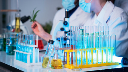 A group of young scientists are conducting experiments in the lab using a microscope., Aspiring scientists are busy running laboratory experiments