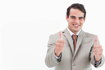 Male professional smiling holding thumbs up in suit with tie against white backdrop, copy space