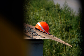 Helmet rests. Work pauses. Safety waits. Orange shines.