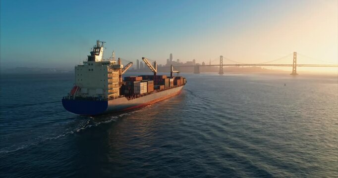 A container ship transports goods across the water near San Francisco, California, USA. The ship is moving cargo for global trade and commerce.