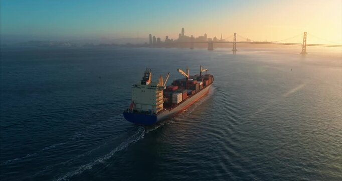 A cargo ship transports goods across the water near San Francisco, California, USA. The ship is moving goods for import and export.