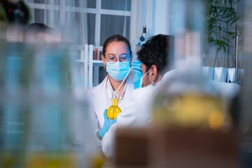 A group of young scientists are conducting experiments in the lab using a microscope., Aspiring scientists are busy running laboratory experiments
