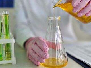 Chemistry experiment involving liquid transfer to a flask in a lab