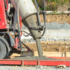 Concrete truck pouring mix into foundation
