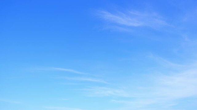 A timelapse of blue sky highlights delicate wisps of cirrus clouds drifting gently, representing stable weather, calm winds, and clear atmospheric conditions, often linked with fair and pleasant days.