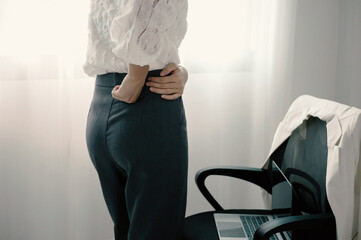 Asian business woman feeling tired and waist pain from sitting f