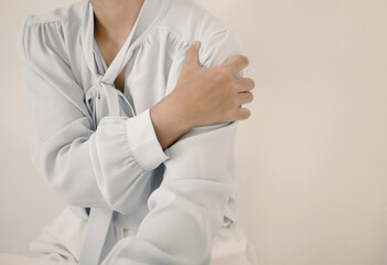 Businesswoman is massaging her shoulder with her hands. Shoulder pain from work fatigue and muscle numbness. Massage and relax muscles. Office syndrome concept