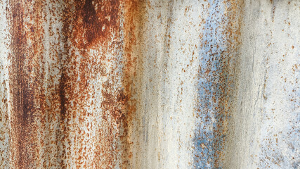 Rust-stained zinc fence wall with vintage feel and aging textures. Corrugated metal surface used for grunge backgrounds, old factory design, and time-worn construction concepts.