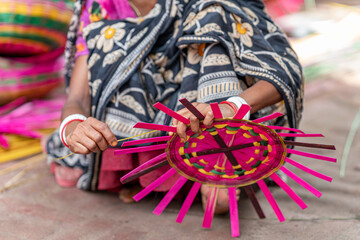 Artisan's Hands Weaving Natural Materials A Close-Up View. Crafting a Colorful Woven Basket. Artisan crafting bamboo basket, close-up view. Artisan's Hands Weaving Natural Materials A CloseUp View.