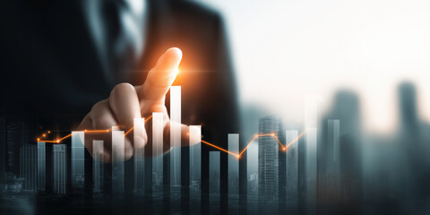A business professional's hand points at rising financial graphs over a cityscape, symbolizing growth and progress in the corporate world.