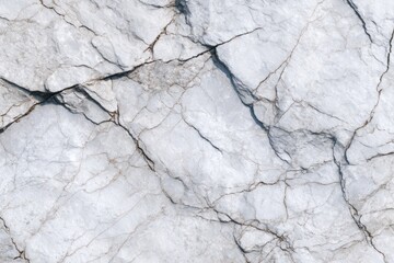Close-up view of a light gray marble surface with prominent cracks and veining