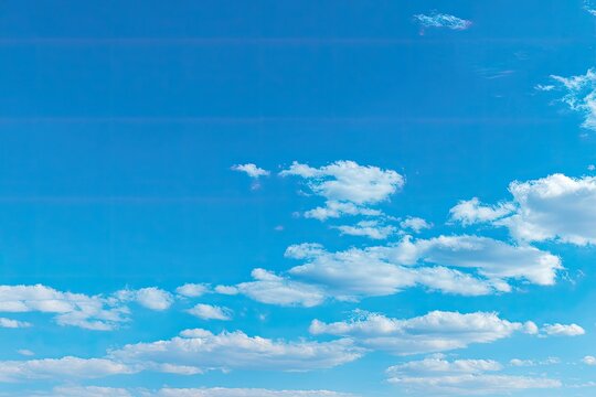 Wide shot of a vibrant blue sky with scattered, puffy white clouds - Powered by Adobe