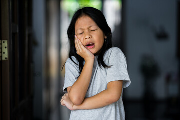 Young asia beautiful girl  touching mouth with hand with painful expression because of toothache or...