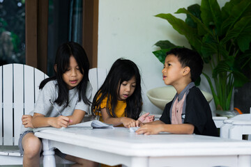Children sitting around table, having discussion at home