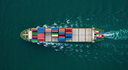 Large container ship sailing across the ocean creating waves