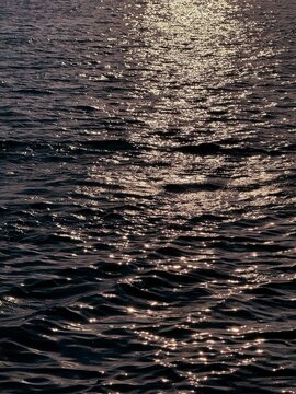Glittering ocean water surface at night. 