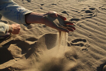 White sand in a man's hand close-up. Drought problem