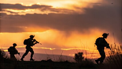 Military team moving at dusk &mdash; silhouettes against fiery evening sky