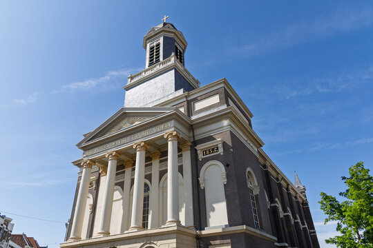 The grand Hartebrugkerk in Leiden, a beautiful historic church with neoclassical elements and a prominent tower under a clear blue sky.