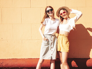 Two young beautiful smiling hipster female in trendy summer clothes.Sexy carefree women posing on...