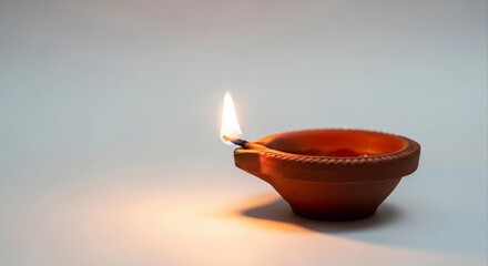 Diwali oil lamp with flame on clean background