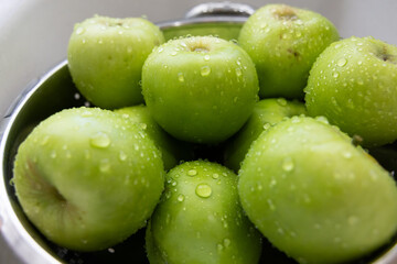 Green Granny Smith Apples in bowl in Kitchen Sink
