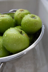 Green Granny Smith Apples in bowl in Kitchen Sink