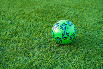 Fototapeta premium Soccer ball on green artificial grass football field background