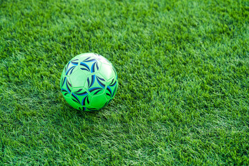 Fototapeta premium Soccer ball resting on synthetic field artificial green surface