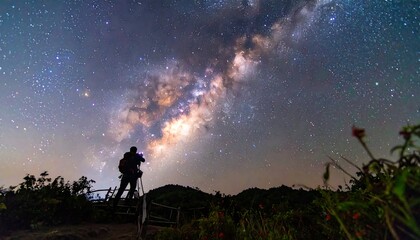 Obraz premium A photographer on a mountaintop captures the Milky Way