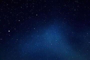 Obraz premium Dark night sky filled with scattered stars. A hazy, light-blue area suggests a nebula or distant galaxy