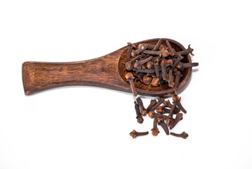dried cloves in the wooden spoon, isolated on white background