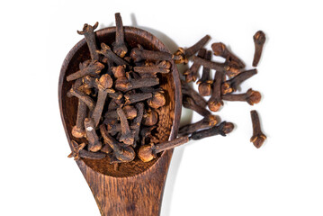 dried cloves in the wooden spoon, isolated on white background