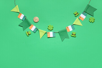 Paper garland with Irish flags for St. Patrick's Day celebration on green background